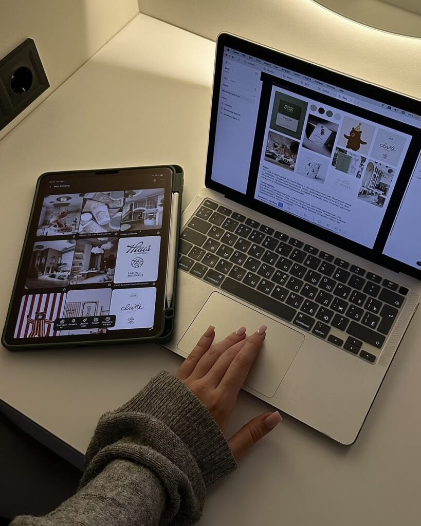 Cozy minimalist workspace with a laptop and tablet displaying branding inspiration boards.cv